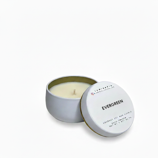 Open white metal tin candle with lid labeled 'Evergreen' placed on a white background