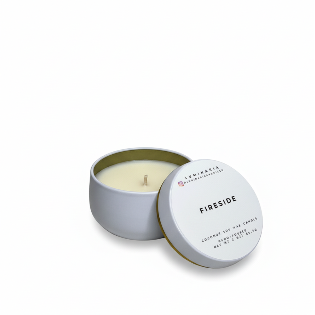 Open white metal tin candle with lid labeled 'Fireside' placed on a white background