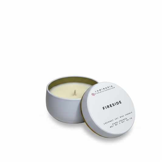 Open white metal tin candle with lid labeled 'Fireside' placed on a white background