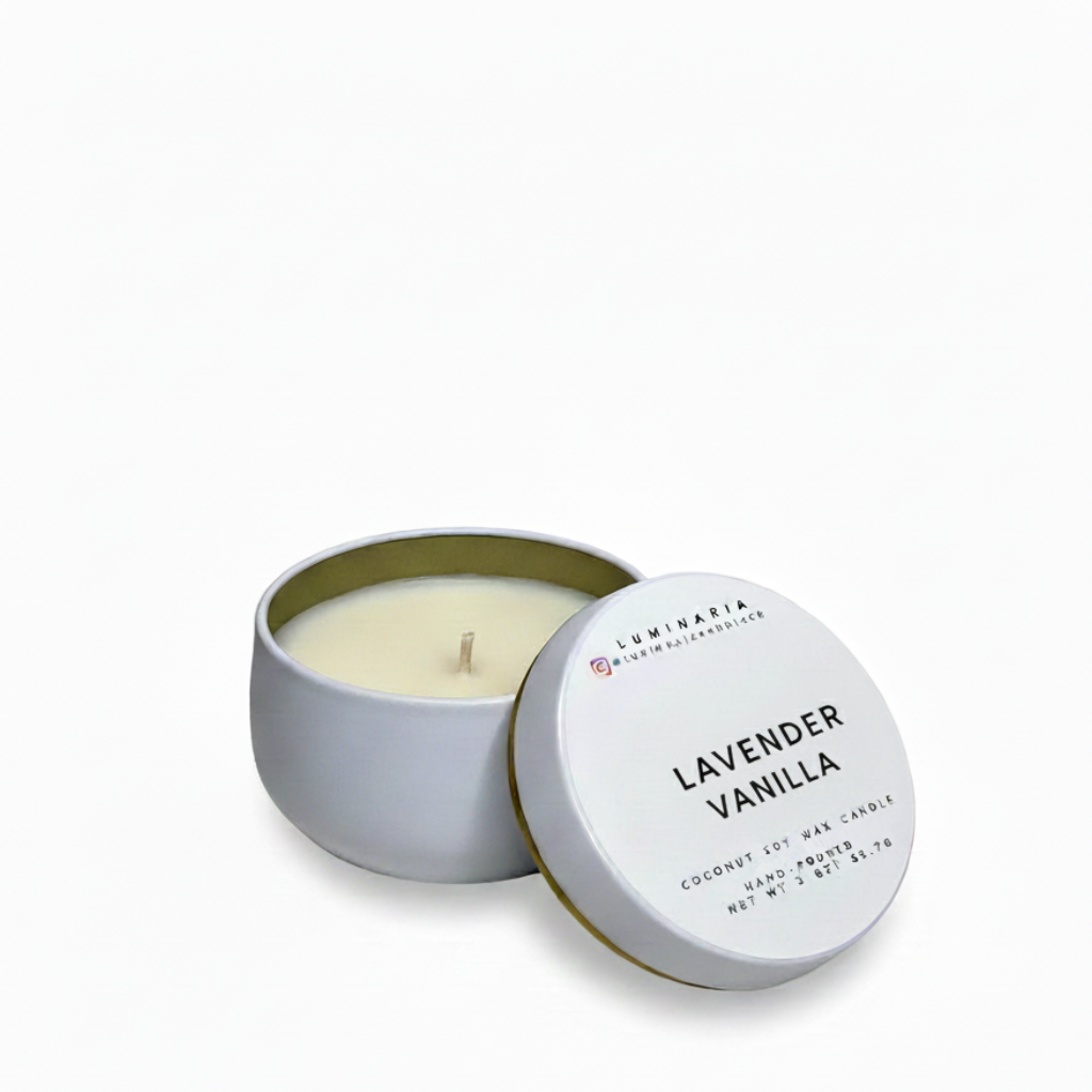 Open white metal tin candle with lid labeled 'Lavender Vanilla' placed on a white background