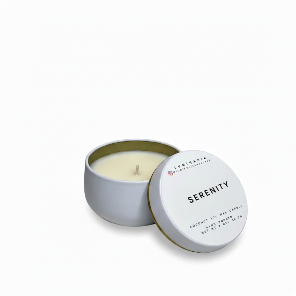 Open white metal tin candle with lid labeled 'Serenity' placed on a white background