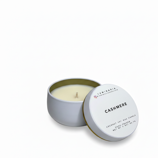 Open white metal tin candle with lid labeled 'Cashmere' placed on a white background